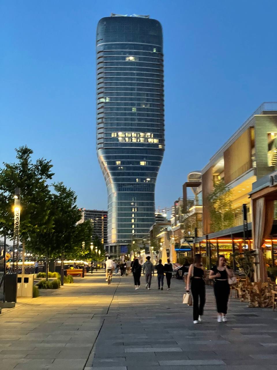 Evening promenade on the Belgrade waterfront with a glass tower behind